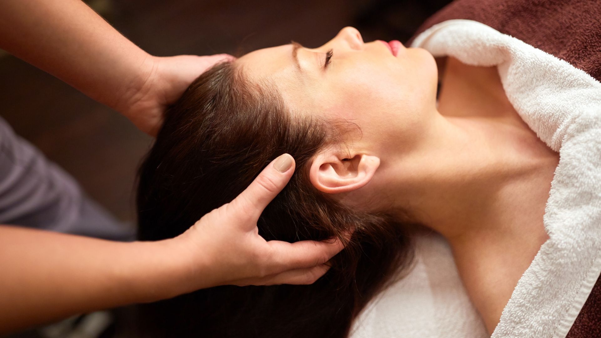A dry head spa: a scalp massage performed without water, the guest lying back with a towel across the shoulders