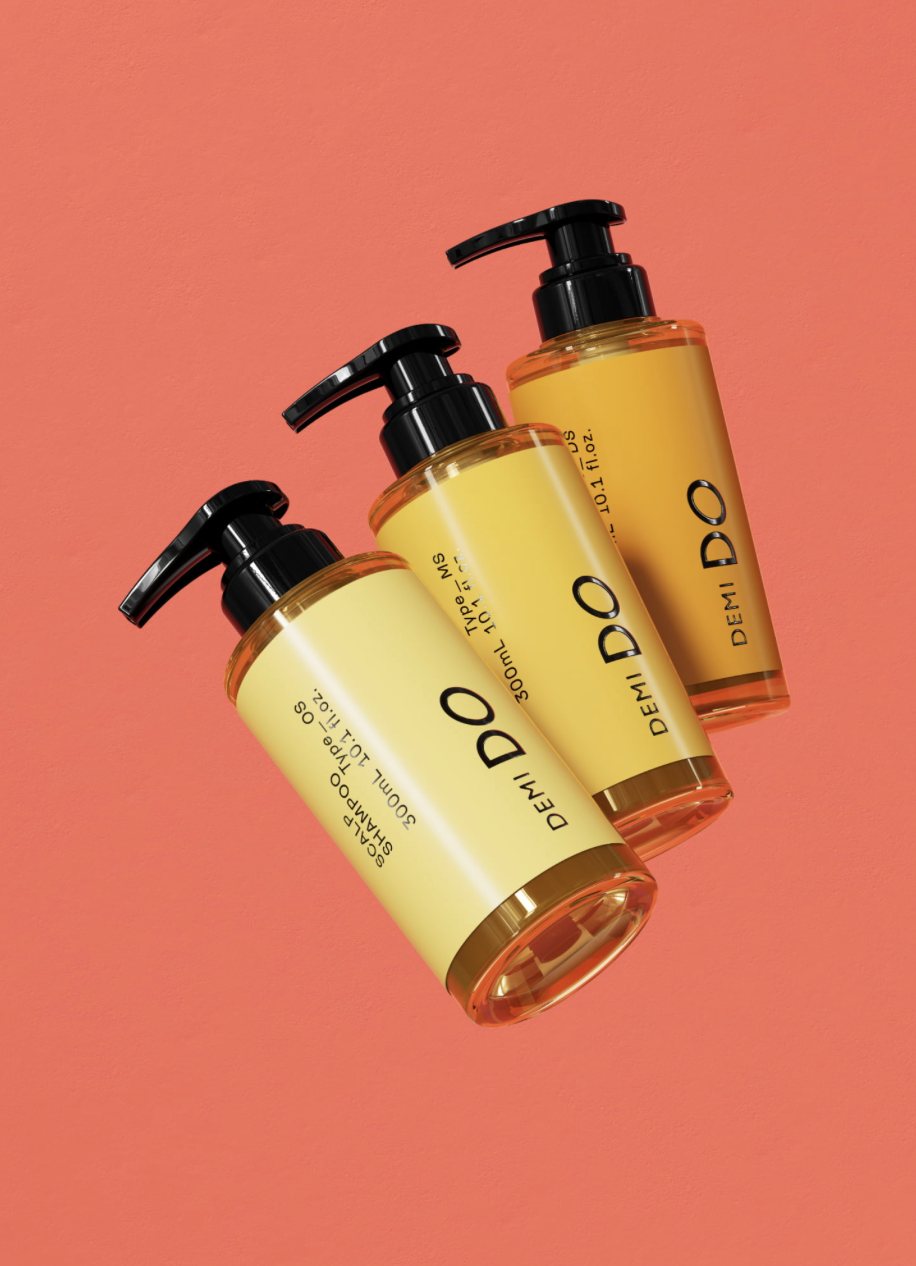 Salon treatment bottles standing together against a warm coral background