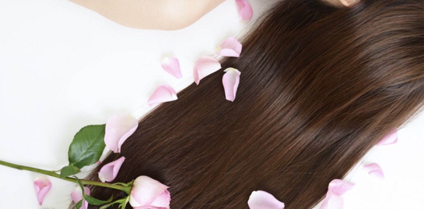 Glossy brown lengths laid out among soft pink petals